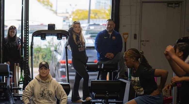A group training session in the CT Fitness gym in Milton, with athletes lunging across an open floor and a coach watching